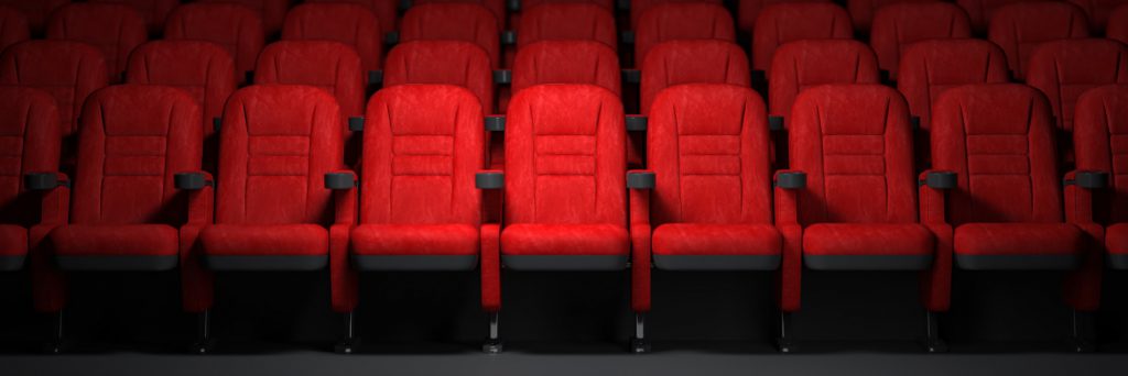 Red seats rows in empty cinema hall. Movie theatre and cinema concept.